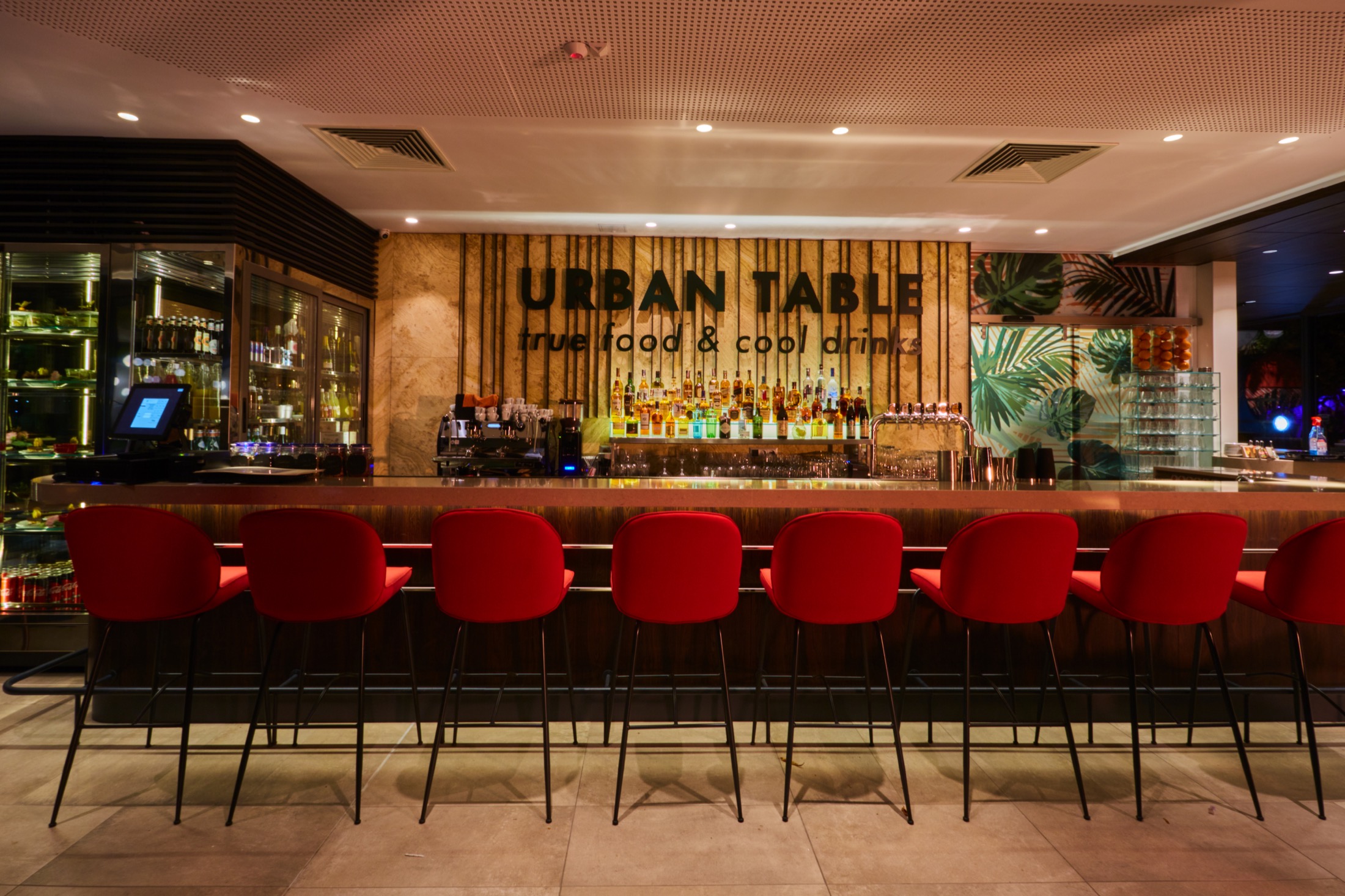 Фронтален изглед към бара на Urban Table с червени бар столове